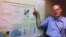 Tokyo University professor Robert Geller points to a poster of a soon-to-be-published document he co-authored asserting characteristic earthquake models developed in the past should be considered dead and buried. (Photo: VOA/Steve Herman)