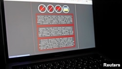 A laptop screen displays a warning message in Ukrainian, Russian and Polish that appeared on the official website of the Ukrainian Foreign Ministry after a massive cyberattack, in this illustration taken Jan. 14, 2022. 