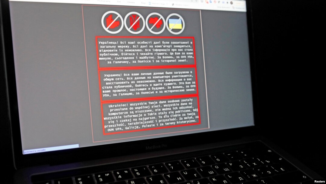 FILE - A laptop screen displays a warning message in Ukrainian, Russian and Polish that appeared on the official website of the Ukrainian Foreign Ministry after a massive cyberattack, Jan. 14, 2022. 