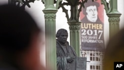 지난 2017년 10월 31일 독일 비텐베르크에서 열린 종교개혁 500주년 기념행사에 앞서 관광객들이 마르틴 루터 동상 앞을 지나 걸어가고 있다. 