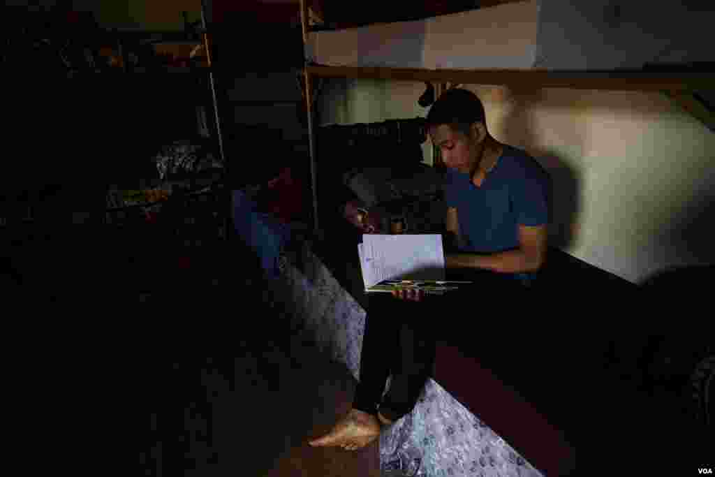 A young men from Trinidad and Tobago reads in his room in al-Houri Rehabilitation Center. He came to Syria in 2014 when his stepfather joined IS and has been kept in this center for more than five years, on Oct. 9, 2024. (Diego Baravelli/VOA)