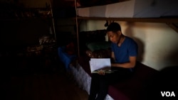 A young men from Trinidad and Tobago reads in his room in al-Houri Rehabilitation Center. He came to Syria in 2014 when his stepfather joined IS and has been kept in this center for more than five years, on Oct. 9, 2024. (Diego Baravelli/VOA)