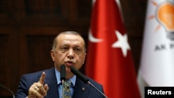 FILE - Turkish President Tayyip Erdogan addresses members of parliament from his ruling AK Party (AKP) during a meeting at the Turkish parliament in Ankara, Turkey, Oct. 23, 2018.