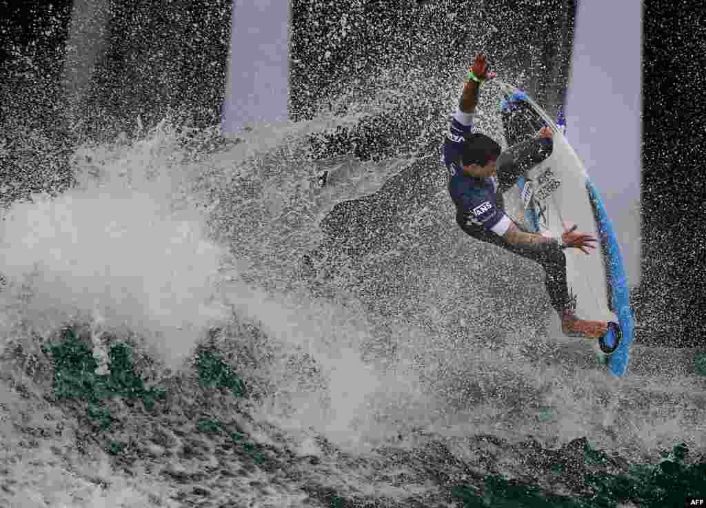 Alex Ribeiro of Brazil competes beside the pier during round four of the Vans US Open of Surfing,&nbsp; held at iconic Huntington Beach, California.