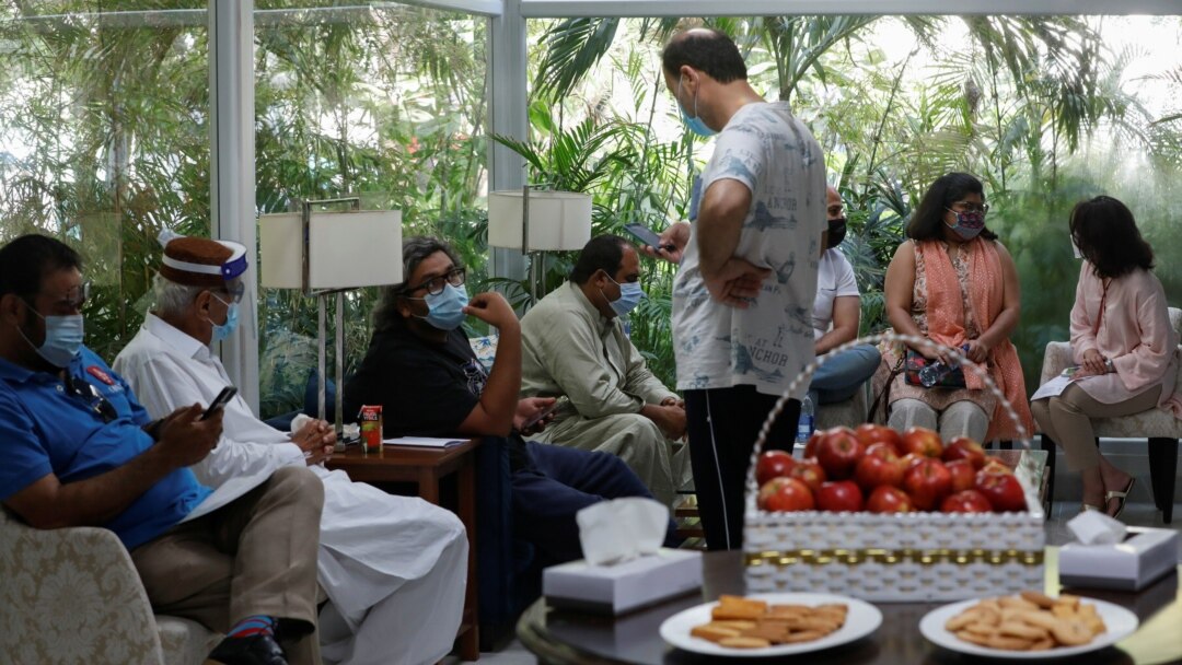 شہری کراچی کے ایک نجی اسپتال میں ویکسین لگوانے کے لیے انتظار گاہ میں بیٹھے ہیں۔