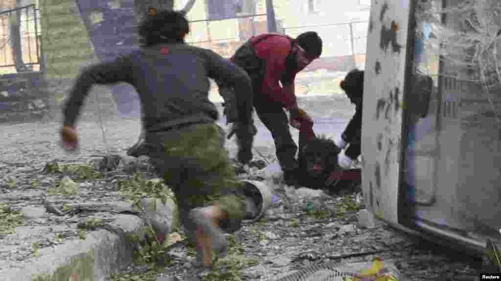 Free Syrian Army fighters rush to help their fellow fighter after he was shot by a sniper.