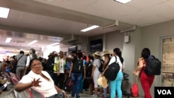 Cuban tourists line up to board their flight at the Toussaint Louverture airport in Port-au-Prince, Haiti. (S. Lemaire/VOA) 