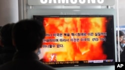 韓國民眾在火車站觀看一個播放北韓宣傳片的電視節目
