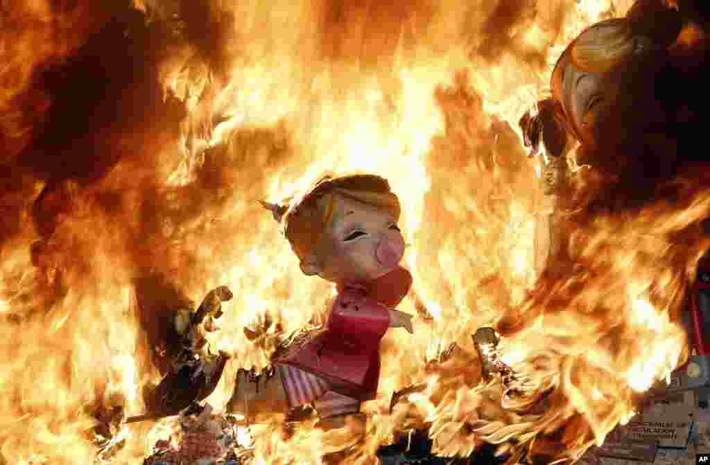 Humorous sculptures burn during the traditional Las Fallas festival in Valencia, Spain.