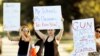 FILE - Angelina Lazo, center, an 18-year-old senior at Marjory Stoneman Douglas High School, who said she lost two friends in the shooting at her school, joins other gun control proponents with placards at a street corner in Coral Springs, Florida, Feb. 16, 2018.