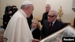 Pope Francis receives a gift from film director Martin Scorsese (right) during a private audience at the Vatican Nov. 30, 2016. 