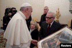 Pope Francis receives a gift from film director Martin Scorsese (right) during a private audience at the Vatican Nov. 30, 2016.