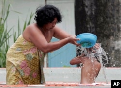 A Thai mother washes her daughter in this 2011 photo. (AP PHOTO)