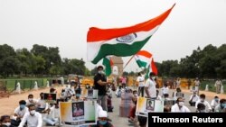 A police officer heckles a supporter of India's main opposition Congress party as others pay tribute to the Indian army soldiers killed in a border clash with Chinese troops in Ladakh region, at India Gate, in New Delhi, June 26, 2020.