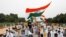 A police officer heckles a supporter of India's main opposition Congress party as others pay tribute to the Indian army soldiers killed in a border clash with Chinese troops in Ladakh region, at India Gate, in New Delhi, June 26, 2020.