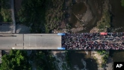 Personas esperan en Juana Méndez, Haití, para cruzar a Dajabón, República Dominicana, el viernes 17 de mayo de 2024. El aumento de inmigrantes haitianos ha llevado a las autoridades dominicanas a informar sobre deportaciones masivas de manera inmediata.