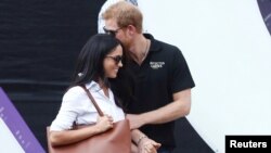 Britain's Prince Harry (R) arrives with girlfriend actress Meghan Markle at the wheelchair tennis event during the Invictus Games in Toronto, Ontario, Canada, Sept. 25, 2017. 