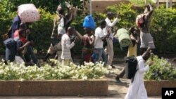 Civilians flee with their belongings in Abidjan, Ivory Coast, April 5, 2011