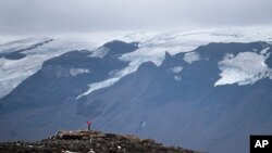 A man stops on his way to the top of what once was the Okjokull glacier, in Iceland, Aug. 18, 2019. 