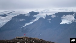 Seorang pria berhenti di puncak yang sebelumnya adalah gletser Okjokull, Islandia, 18 Agustus 2019. 