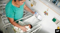 FILE - A nurse bottle feeds a newborn baby at a maternity ward of the University Hospital in Tegucigalpa, Honduras, July 26, 2016.