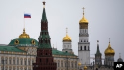 A Russian national flag is seen atop of the Grand Kremlin Palace an hour before Russian President Vladimir Putin addressed the Federal Assembly in the Kremlin in Moscow, Tuesday, March 18, 2014