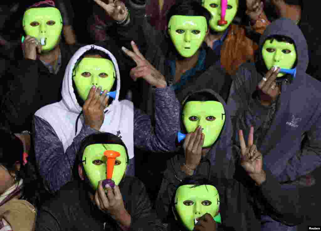 Người dân đeo mặt nạ, thổi kèn trong lúc tham dự một sự kiện đếm ngược chào đón năm mới tại thành phố Ahmendabad, Ấn Độ, 31/12/2018. 