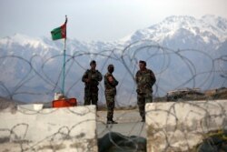 FILE - Afghan National Army soldiers stand guard at a checkpoint near the Bagram base in northern Kabul, Afghanistan, April 8, 2020.