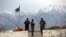 FILE - Afghan National Army soldiers stand guard at a checkpoint near the Bagram base in northern Kabul, Afghanistan, April 8, 2020.