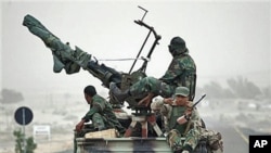 Libyan rebels who are part of the forces against Libyan leader Moammar Gadhafi ride in a truck carrying an anti-aircraft gun on their way to the front-line near Ras Lanuf, west of the town of Brega, eastern Libya, March 4, 2011
