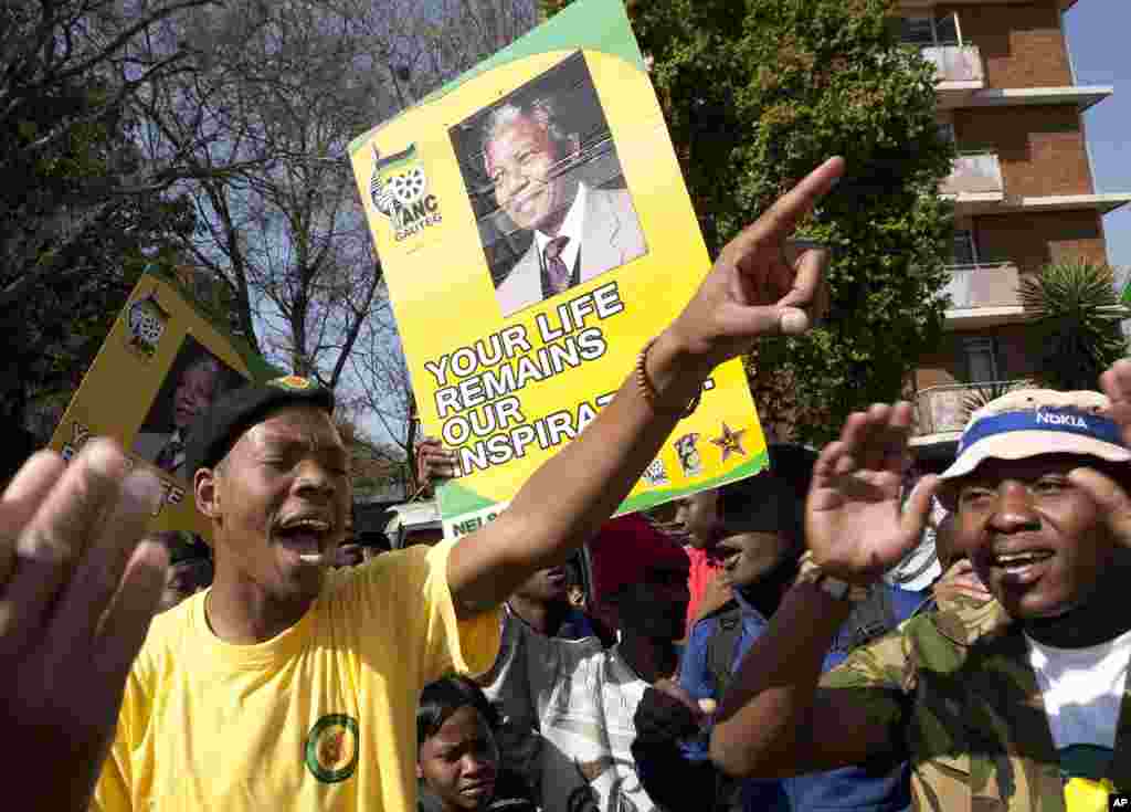 Members of the ruling party youth league sing outside the Mediclinic Heart Hospital where Nelson Mandela is being treated in Pretoria, July 17, 2013.
