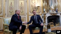 President Donald Trump shakes hands with French President Emmanuel Macron inside the Elysee Palace in Paris Saturday Nov. 10, 2018.