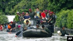 Para anggota marinir melakukan evakuasi beberapa warga yang terjebak banjir di Jakarta, Minggu (20/1).