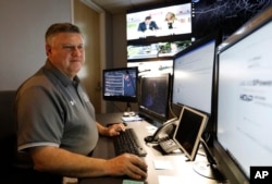 In this July 30, 2019, photo, Paul Hildreth, emergency operations coordinator for the Fulton County School District, works in the emergency operations center at the Fulton County School District Administration Center in Atlanta. (AP Photo/Cody Jackson)