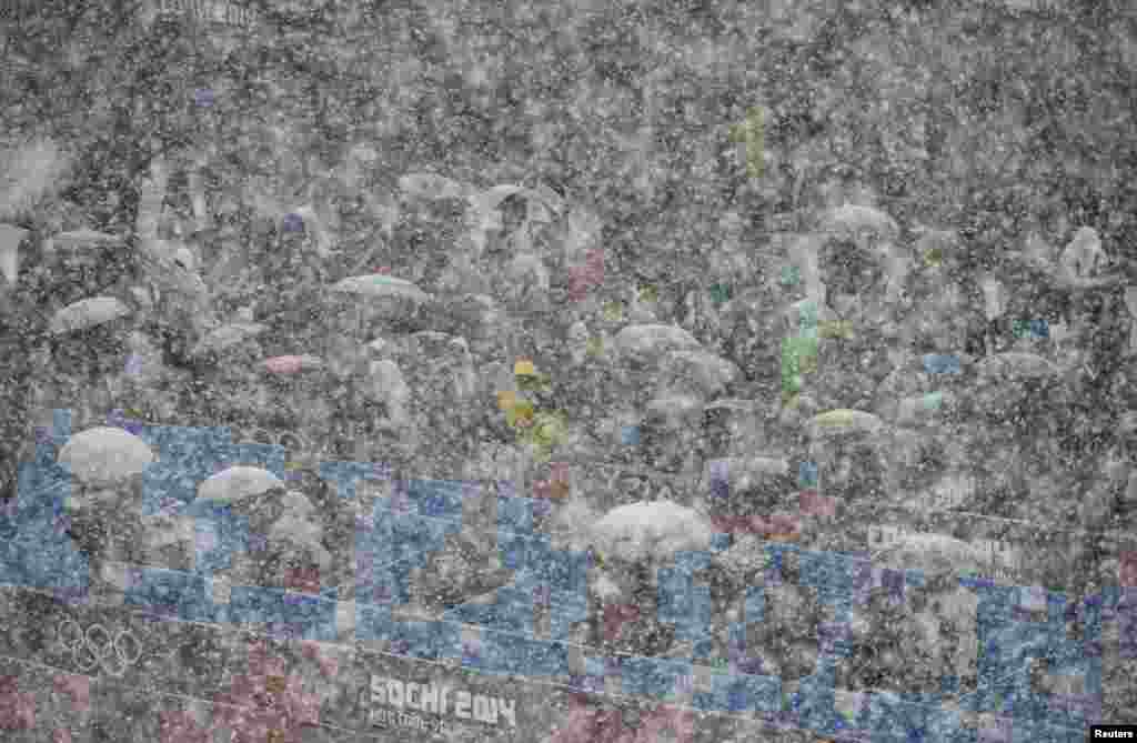 Spectators look on in the snow during the men&#39;s freestyle skiing halfpipe qualification round at the 2014 Sochi Winter Olympic Games in Rosa Khutor in Russia.