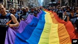 Revelers carry a LGBTQ flag along Fifth Avenue during the 2018 Gay Pride Parade in New York City, June 24, 2018.