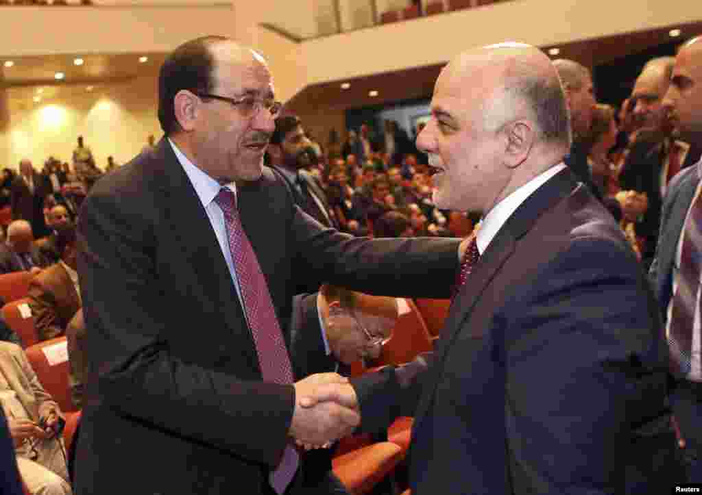 Iraq&#39;s Vice President Nouri al-Maliki (left) and incoming Prime Minister Haider al-Abadi shake hands during the session to approve the new government in Baghdad, Sept. 8, 2014.