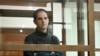 FILE - Wall Street Journal reporter Evan Gershkovich stands in a glass cage in a courtroom at the Moscow City Court, in Moscow, Russia, on Dec. 14, 2023. 