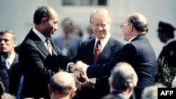 រូបឯកសារ៖ លោក Jimmy Carter (កណ្តាល) ប្រធានាធិបតីអេហ្ស៊ីបលោក Anwar al-Sadat (ឆ្វេង)និងនាយករដ្ឋមន្ត្រីអ៊ីស្រាអែលលោក Menachem Begin (ស្តាំ) ចាប់ដៃគ្នានៅថ្ងៃទី២៦ ខែមីនា ឆ្នាំ១៩៧៩ ក្រោយពីចុះហត្ថលេខាលើសន្ធិសញ្ញាសន្តិភាពរវាងអ៊ីស្រាអែល និងអេហ្ស៊ីបដែលគាំទ្រដោយអាមេរិក នៅរដ្ឋធានីវ៉ាស៊ីនតោន។