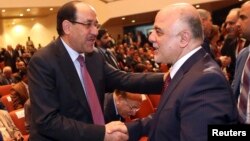 Iraq's Vice President Nouri al-Maliki (L) and new Prime Minister Haider al-Abadi shake hands during the session to approve the new government in Baghdad, September 8, 2014.Iraq's parliament approved a new government headed by Haider al-Abadi as prime mini