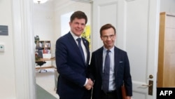 Swedish Speaker of Parliament Andreas Norlen (R) shakes hands with Swedish Moderat Party leader Ulf Kristersson at the Parliament in Stockholm, Sweden, on Oct. 2, 2018.