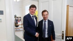 Swedish Speaker of Parliament Andreas Norlen (R) shakes hands with Swedish Moderat Party leader Ulf Kristersson at the Parliament in Stockholm, Sweden, on Oct. 2, 2018.