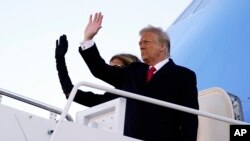Presiden Trump dan ibu negara AS Melania, melambaikan tangan sebelum memasuki pesawat Kepresidenan AS, Air Force One untuk terakhir kalinya, di bandara militer Andrew, Maryland, 20 Januari 2021. 