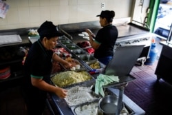 Mujeres preparan pupusas (comida tradicional salvadoreña) para el restaurante Pupuseria Lilian, en Antitguo Cuscatlan, El Salvador, 18 de marzo de 2020.