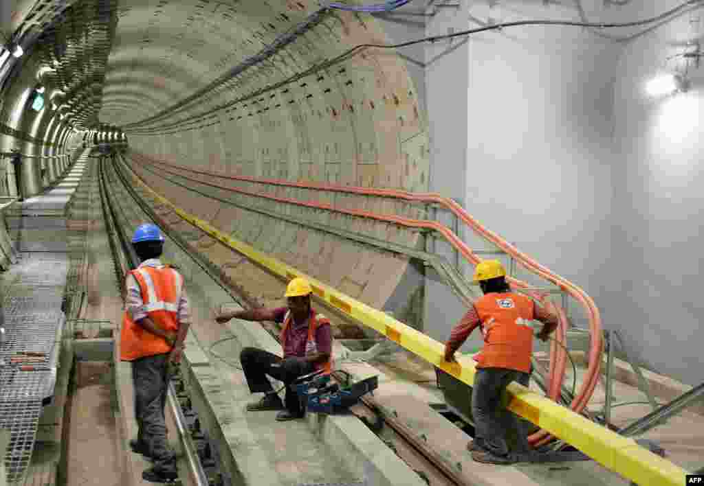 Indian employees of the Namma Metro Rail carry out inspection work near a tunnel that will connect two major parts of Bangalore.