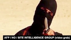 FILE - An image taken from a video released by the Islamic State group purportedly shows a masked militant holding a knife and gesturing as he speaks to the camera before beheading U.S. freelance writer Steven Sotloff. 