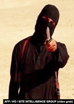 FILE - An image taken from a video released by the Islamic State group purportedly shows a masked militant holding a knife and gesturing as he speaks to the camera before beheading U.S. freelance writer Steven Sotloff.