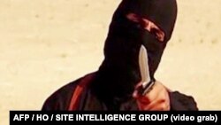 FILE - An image taken from a video released by the Islamic State group purportedly shows a masked militant holding a knife.