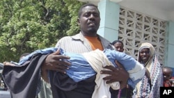 A man from southern Somalia carries the body of his dead child from Banadir hospital in Mogadishu, Somalia, Monday, July 25, 2011