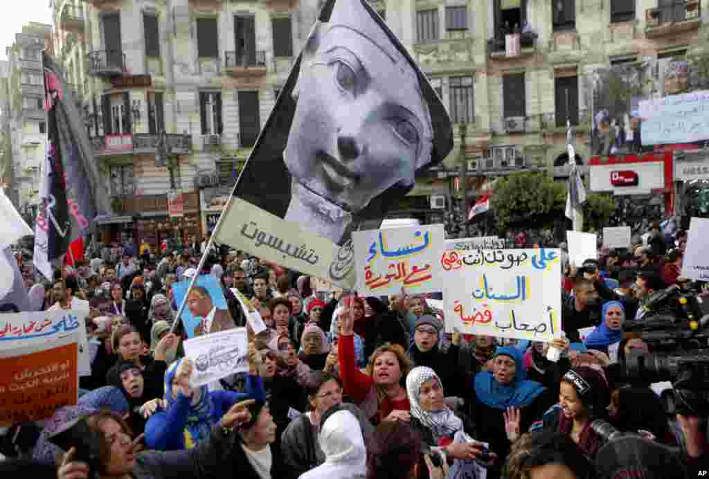 Women wave a flag showing pharaoh Queen Hatshepsut, the only woman that ruled Egypt, and anti-Muslim Brotherhood banners during a demonstration to mark International Women's Day, Cairo, Egypt, March 8, 2013. 